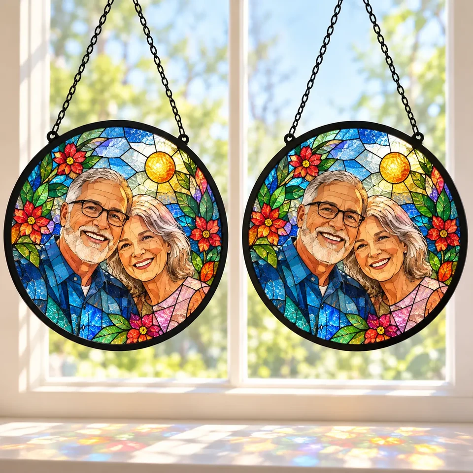 Custom family portrait stained glass suncatcher hanging in a bright living room window